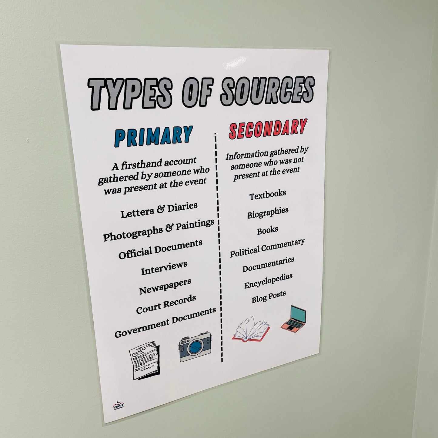 Live look at types of sources anchor chart hanging in classroom which compares primary and seconday sources for students